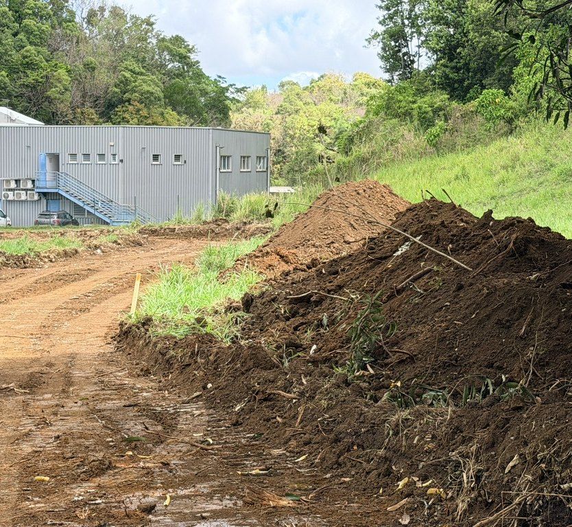 Chantier : terre décapée en andain le long de la future voie